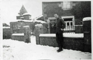 Flynn in front of the house where he and other soldiers stayed in Belgium, February 1945. 